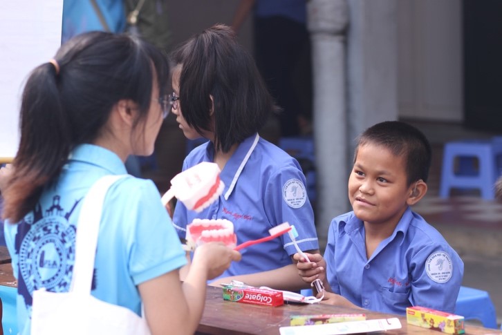 Sinh viên hướng dẫn cách vệ sinh răng miệng cho các em bé tại Trung tâm trẻ em khuyết tật thị xã Thuận An